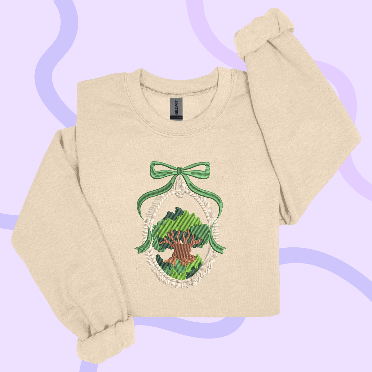 A beige sweater with a green bow and a tree design on the front, set against a purple background.