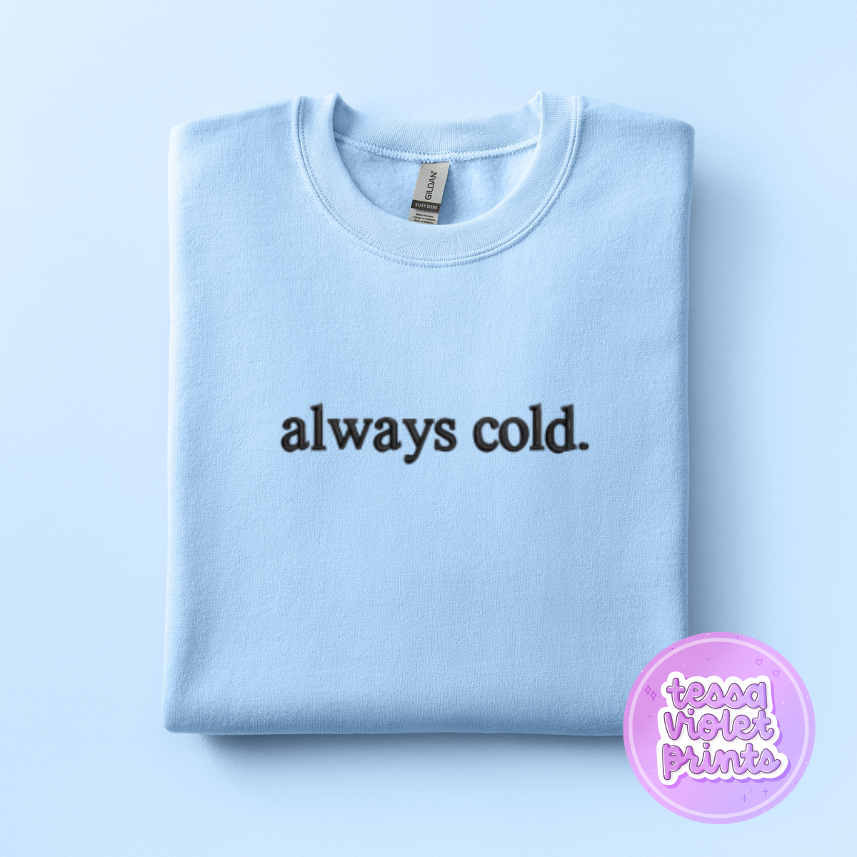 A light blue sweatshirt with the text "always cold" printed on it.