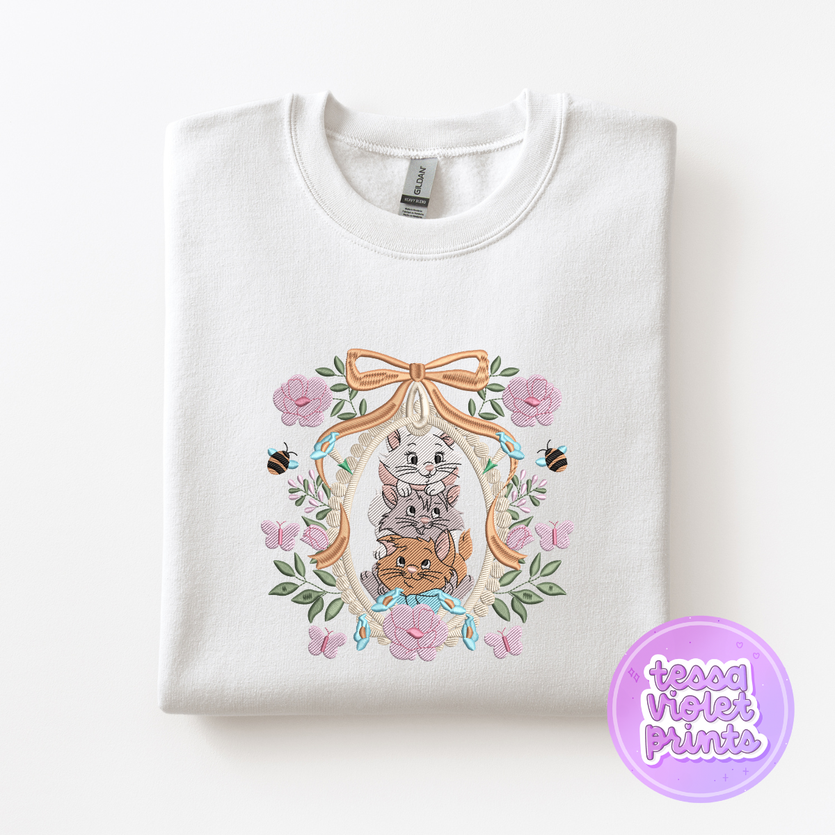 A white sweatshirt with a floral design featuring a bow, cats, and flowers.