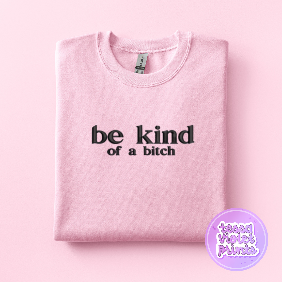 A pink sweatshirt with the text "be kind of aitch" printed on it.