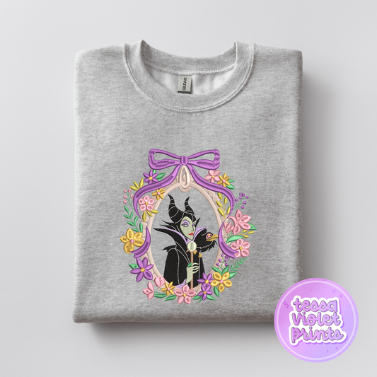 A gray sweatshirt with a graphic design featuring a character from the Disney film "Maleficent" surrounded by a floral border.