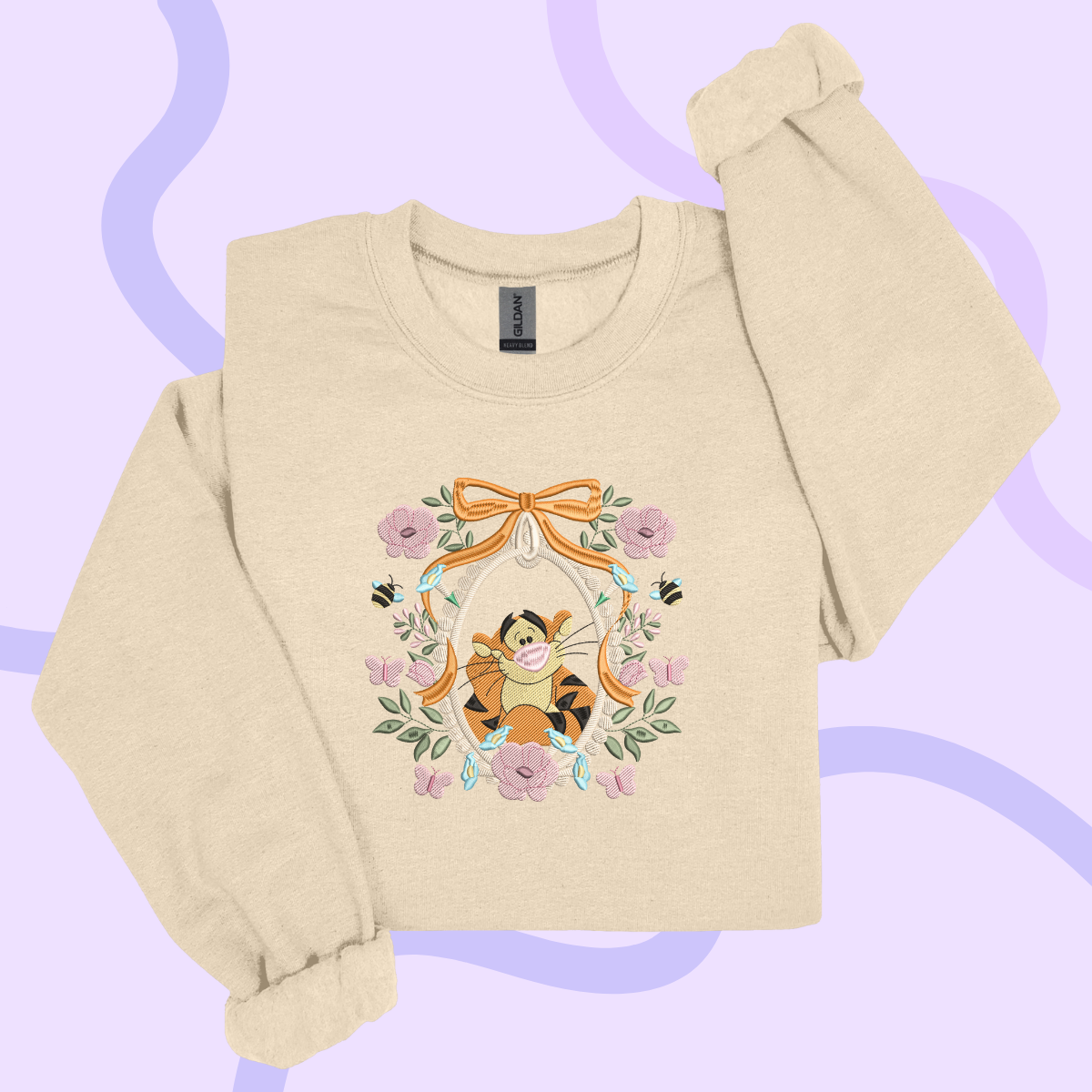 A beige sweater with a floral design featuring a cartoon character, likely Winnie the Pooh, surrounded by flowers and leaves.