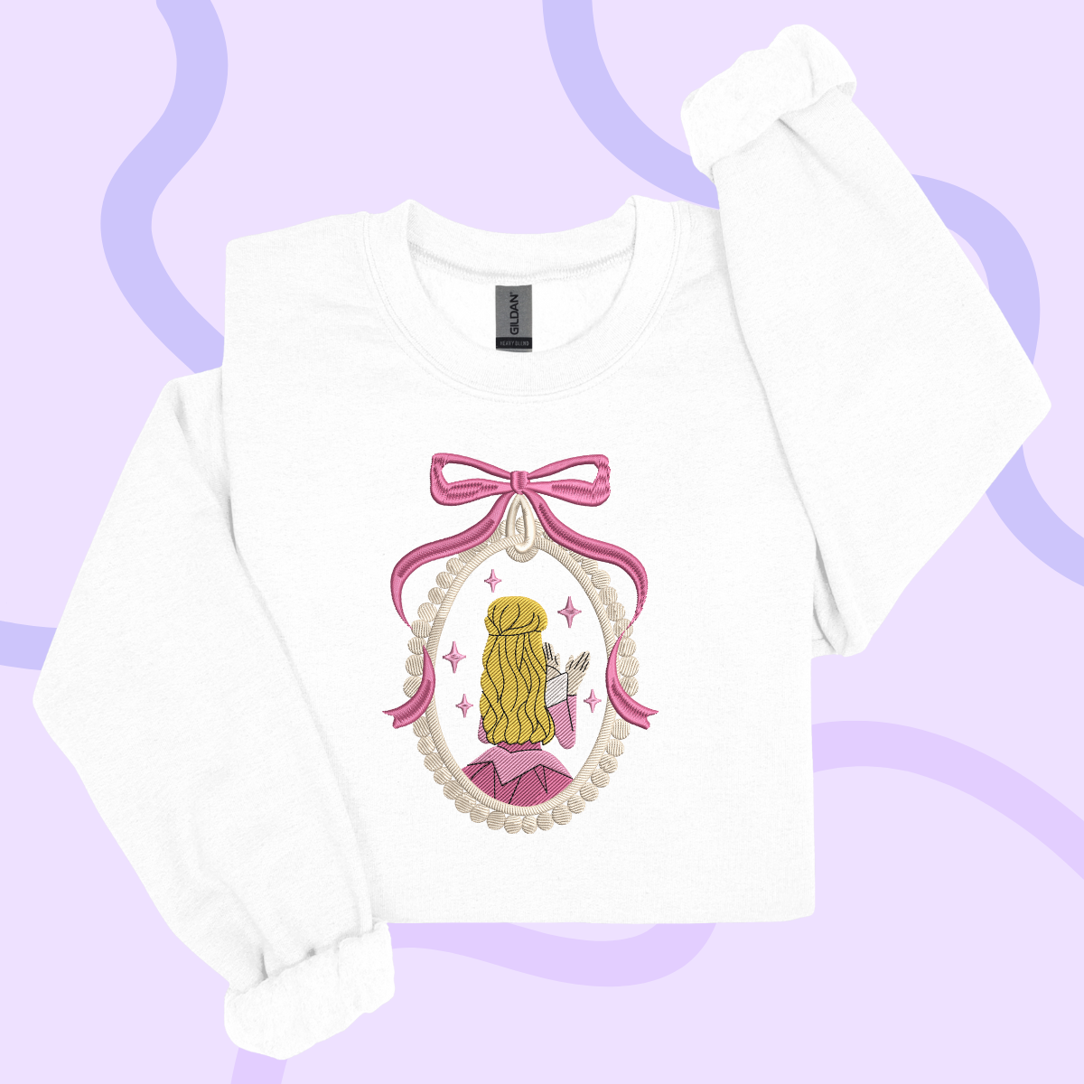 A white long-sleeved shirt with a pink bow and a framed illustration of a woman with blonde hair and a pink dress.