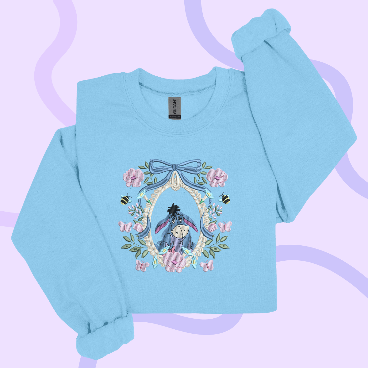A light blue long-sleeved shirt with a floral design featuring a character from the Winnie the Pooh series.