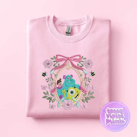 A pink sweatshirt with a floral design featuring characters from the animated film Monsters, Inc.