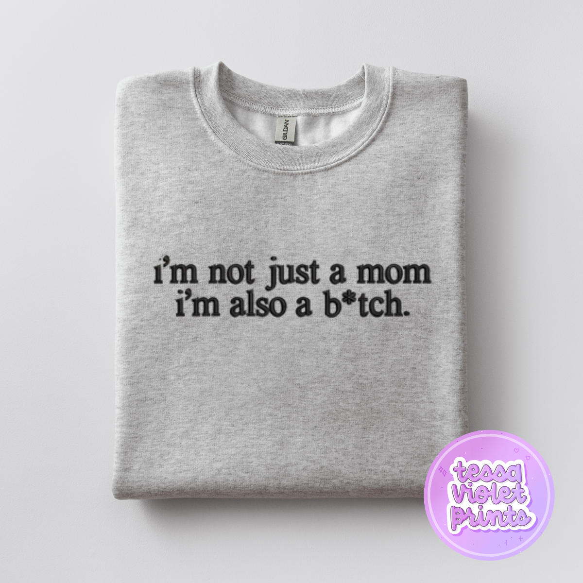 A gray sweatshirt with the text "I'm not just a mom I'm also a b*tch" printed on it.