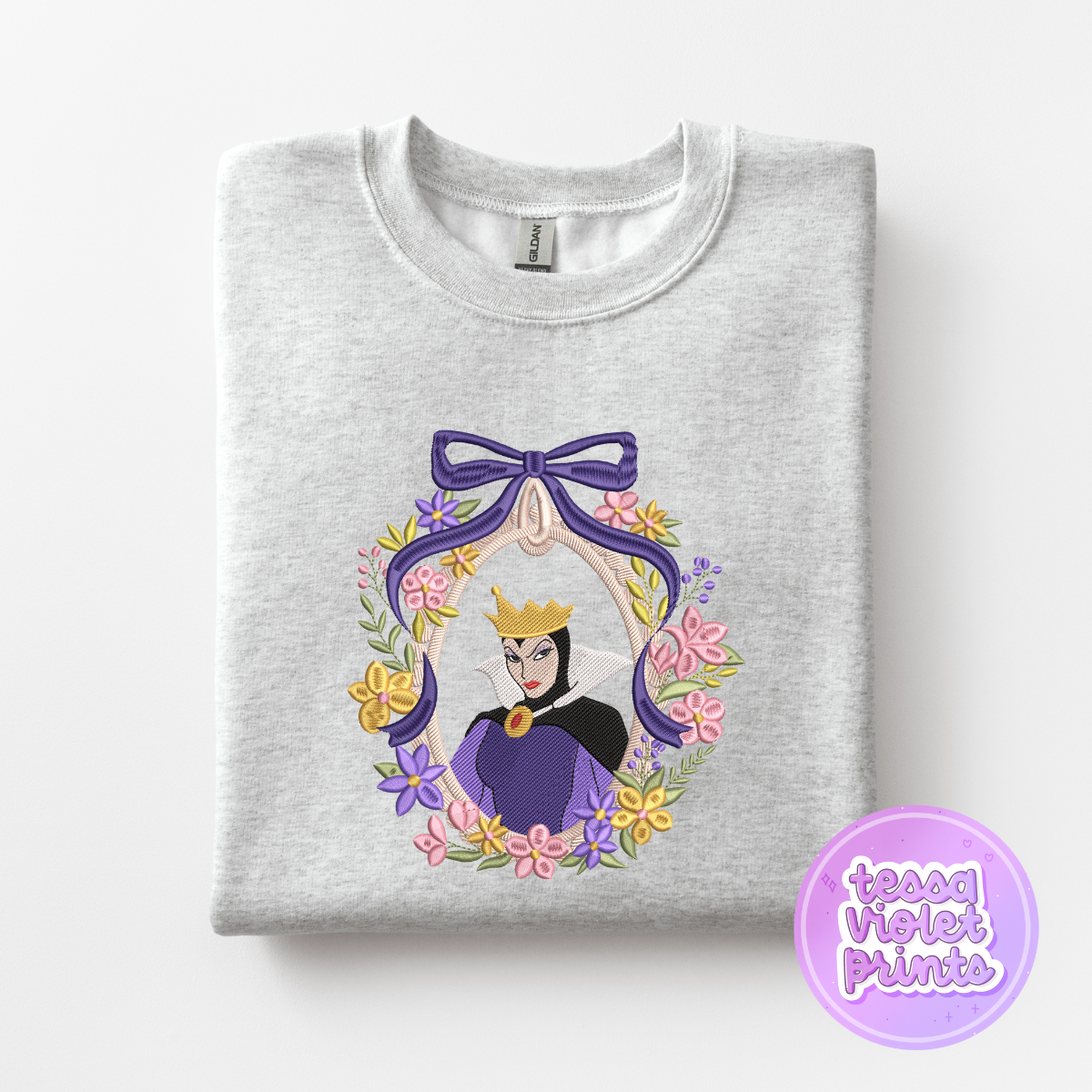 A gray sweatshirt with a colorful embroidered design featuring a character wearing a crown and surrounded by a wreath of flowers.